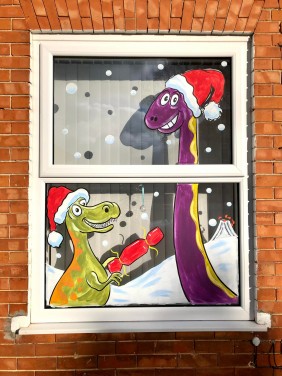 Christmas Window art - Dinosaurs pulling a Cracker